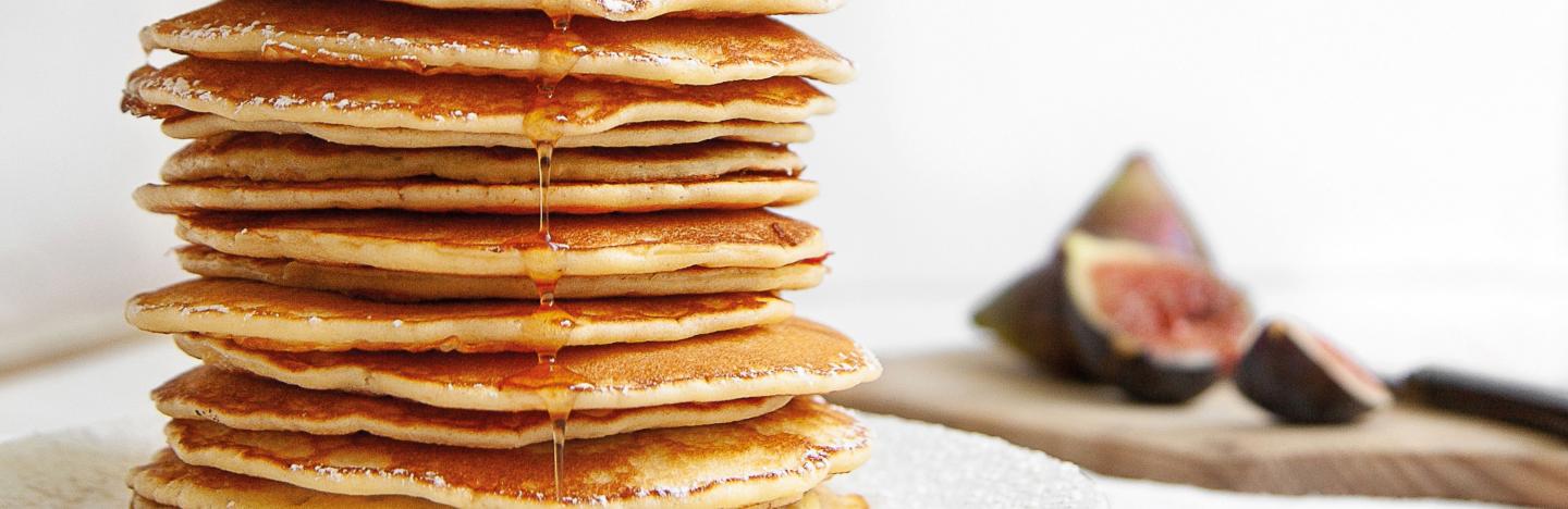 Beaucoup pancakes crêpes superposées au sirop d’érable et figues dans une assiette