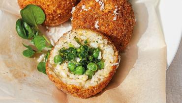 Arancini, boule de riz frite avec chapelure, fourrée aux petits pois verts