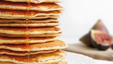 Beaucoup pancakes crêpes superposées au sirop d’érable et figues dans une assiette