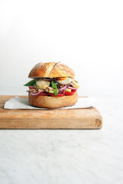 Pan-bagnat sandwich avec pain rond vue de côté, œufs, tomates et thon Pan-bagnat sandwich avec pain rond vue de côté, œufs, tomates et thon