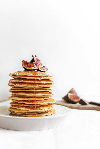 Beaucoup pancakes crêpes superposées au sirop d’érable et figues dans une assiette Beaucoup pancakes crêpes superposées au sirop d’érable et figues dans une assiette