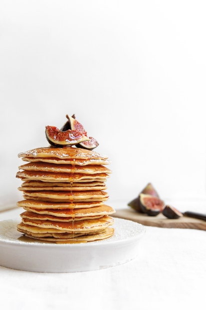 Beaucoup pancakes crêpes superposées au sirop d’érable et figues dans une assiette